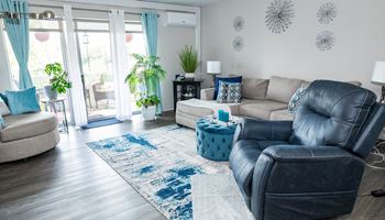 a living room with blue and white furniture and a blue rug